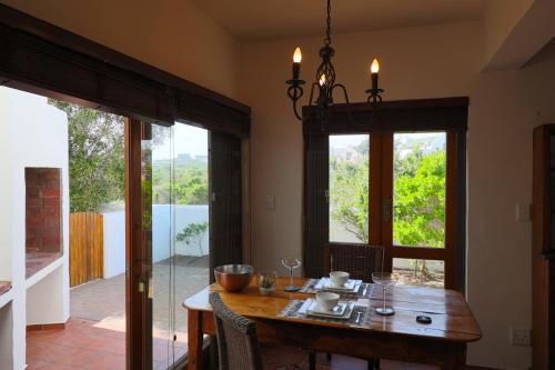 a dining room with a table and a large window at Hallo Jacobsbaai in Jacobs Bay