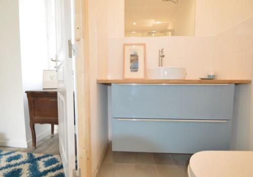ein Bad mit einem Waschbecken und einem Spiegel in der Unterkunft Chez Claire in Excideuil