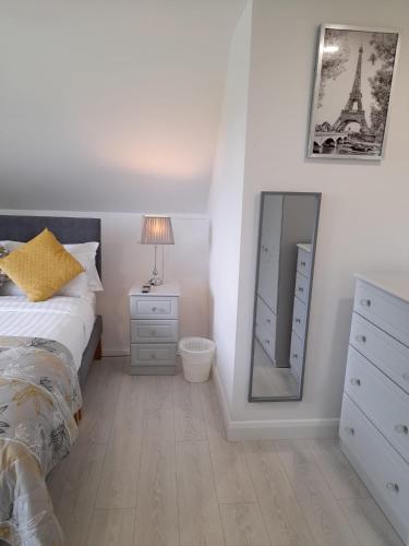 a bedroom with a bed and a dresser and a mirror at Doonan Breeze in Donegal