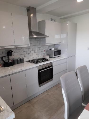 a kitchen with white cabinets and a stove top oven at Doonan Breeze in Donegal