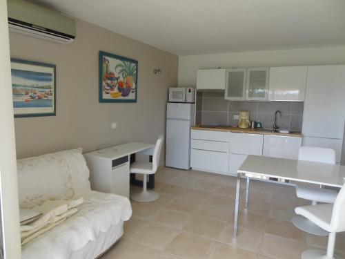 une cuisine et un salon avec un canapé et une table dans l'établissement Les Chèvrefeuilles, à Manosque