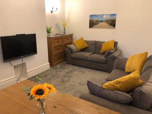 a living room with a couch and a flat screen tv at Cosy Haven in South Shields