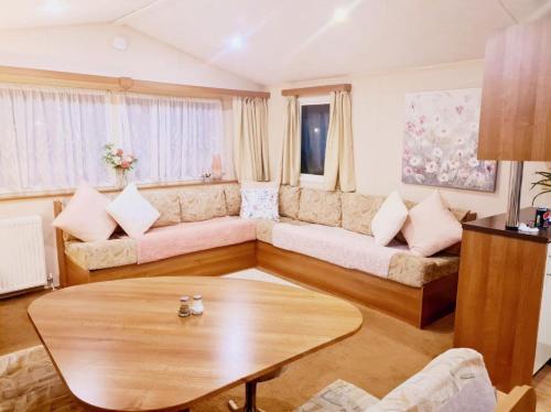 una sala de estar con un sofá y una mesa en Tattershall Lakes Caravan Ezees Holiday Retreat, en Tattershall