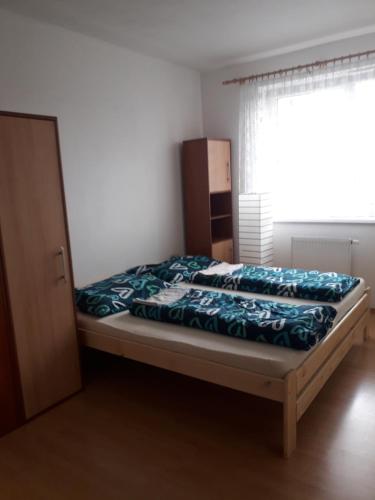 um quarto com uma cama com lençóis azuis e uma janela em apartmán Peškova em Olomouc