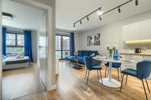 eine Küche und ein Wohnzimmer mit einem Tisch und Stühlen in der Unterkunft EXCLUSIVE FORTY Apartments in Stettin