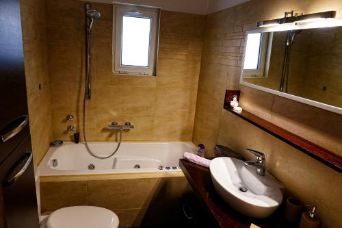 uma casa de banho com uma banheira, um lavatório e um WC. em Cozy Urban Apartment at Agios Dimitrios em Atenas