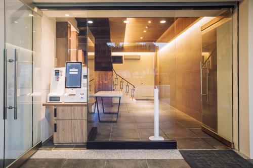 台東市的住宿－旅人驛站日暮微旅，走廊上设有玻璃门,里面装有机器