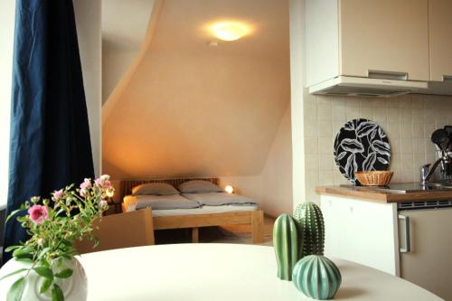 a room with a kitchen with a table and a bed at GROßE-WILDE-BETTEN in Wittdün