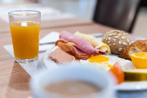 a plate of breakfast food with a glass of orange juice at Hotel Lanzarote Village in Puerto del Carmen