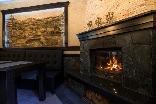 a fireplace in a restaurant with a table and a window at Chalet Carpat Dream in Synevyr