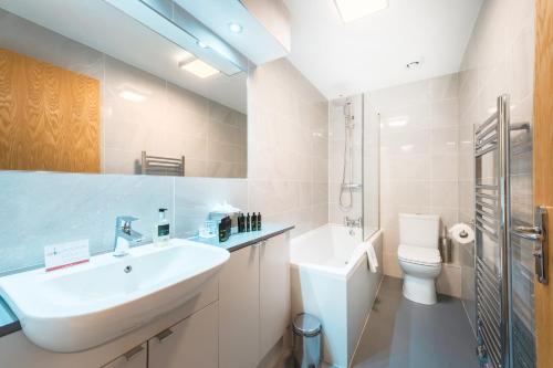 a white bathroom with a sink and a toilet at The Knight Residence by Mansley in Edinburgh