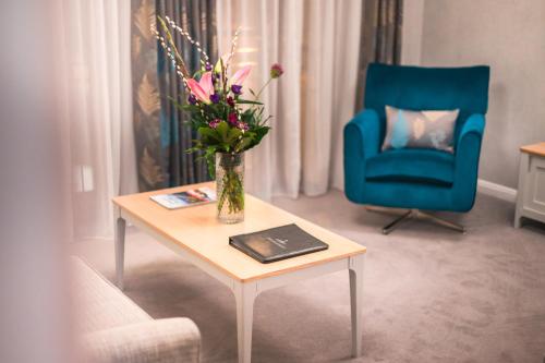 a living room with a vase of flowers on a table at The Knight Residence by Mansley in Edinburgh
