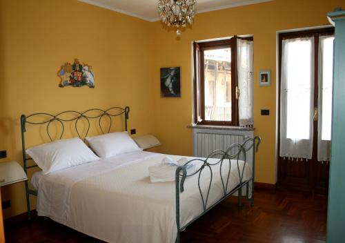 La Robinera في Magnano: غرفة نوم بسرير من الشراشف البيضاء والجدران الصفراء