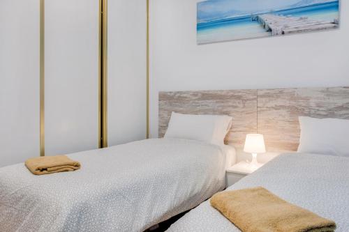 um quarto com duas camas e um candeeiro sobre uma mesa em Three bedroom apartment ii near Sc em Bocacangrejo