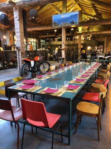 una mesa larga en una habitación con sillas y TV en La Locanda di Grazzano Visconti, en Grazzano Visconti