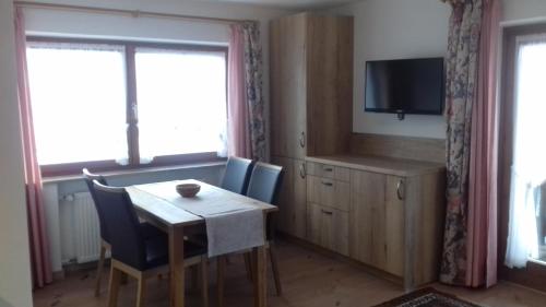 a dining room with a table and a television at Haus Gehmacher-Maier - Chiemgau Karte in Inzell