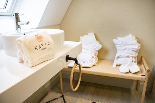 a bathroom with a sink and towels on a bench at Kavia Hotel do Largo in Cascais