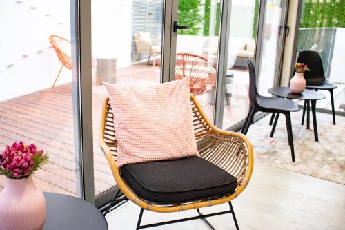 a wicker chair with a pillow on a porch at Kavia Hotel do Largo in Cascais