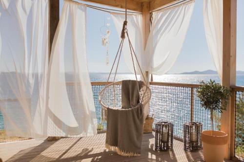 a hammock hanging from a porch with a view of the ocean at Mara's Coast - Frida in Drage