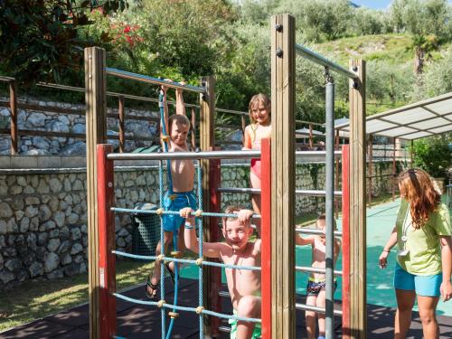 a group of children playing on a playground at Hotel Leonardo Da Vinci in Limone sul Garda