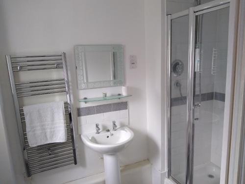 a white bathroom with a sink and a shower at Stylish Private Double Room w/ensuite in London