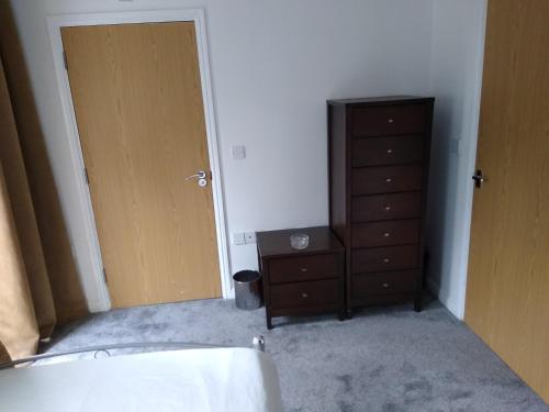 a bedroom with a dresser and a cabinet and a door at Stylish Private Double Room w/ensuite in London