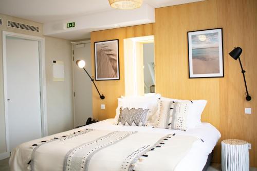 a bedroom with a large white bed with two lamps at Kavia Hotel do Largo in Cascais