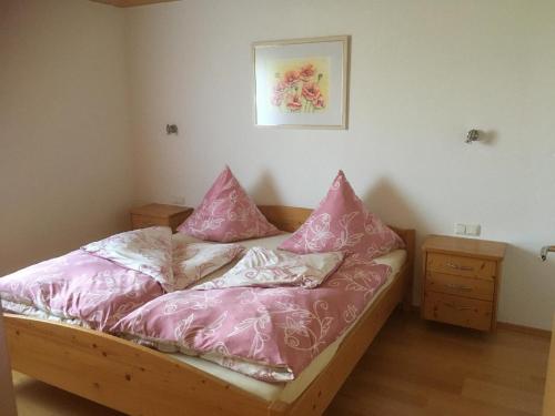 Un dormitorio con una cama con almohadas rosas. en Ferienwohnung Pauli en Zwiesel