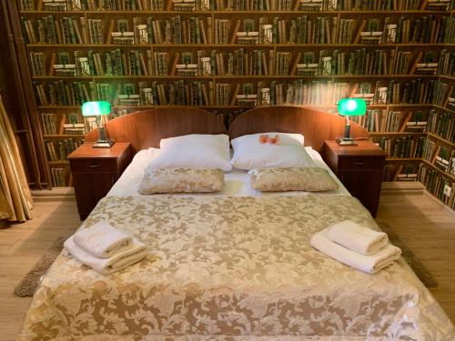 a bedroom with a bed with two lamps and books at Sverchkov 8 Hotel in Moscow