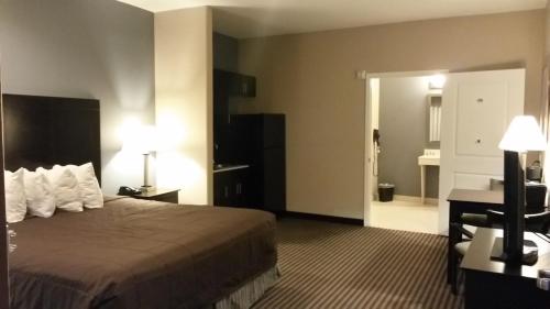 a hotel room with a bed and a desk at Atria Inn & Suites in Three Rivers