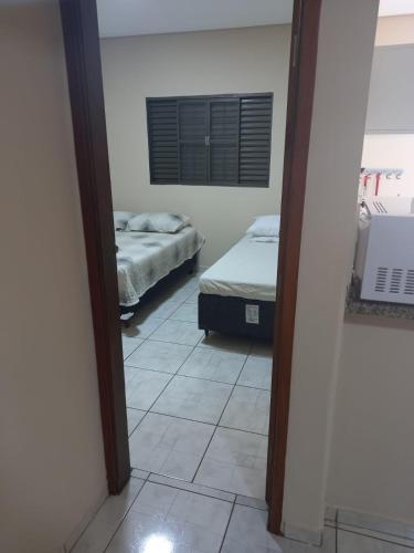 a room with two beds and a mirror at Residencial JOED 3 in Dourados