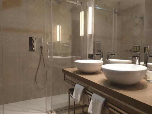 a bathroom with two sinks and a shower at Parador de Plasencia in Plasencia