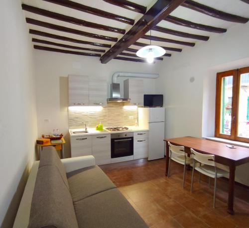 a living room and kitchen with a couch and a table at Casa via della Rocca Luna in Poggibonsi