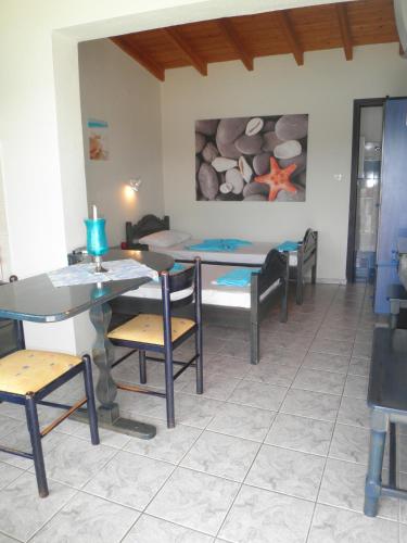 a dining room with a table and chairs and a bed at Babis in Skiathos Town