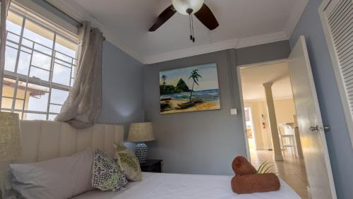 a bedroom with a bed and a ceiling fan at Apartment Soleil- Because Location really is everything! in Soufrière