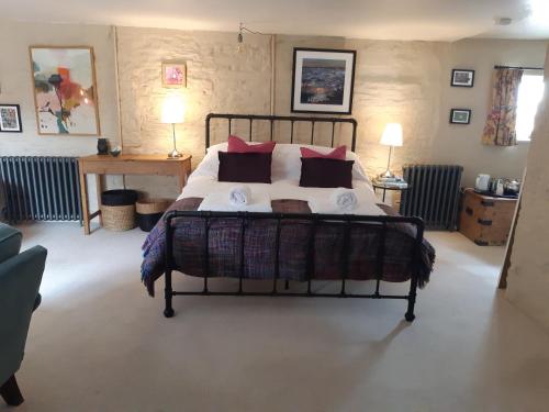 a bedroom with a large bed with red pillows at Huberts, West End Farm, Fosse Lane, Poolbridge Road, Blackford, Wedmore in Wedmore