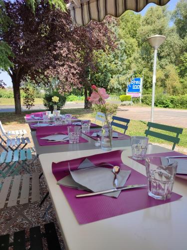 a table with purple napkins and glasses on it at Hôtel Inn Design Resto Novo Bourges in Bourges