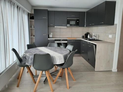 eine Küche mit einem Tisch und Stühlen im Zimmer in der Unterkunft Appartement Panoramic in Nendaz