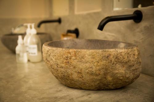 a stone bowl sitting on a counter next to a sink at Olive Grove Guesthouse in Windhoek