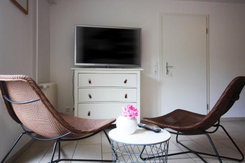 a living room with two chairs and a tv at GROßE-WILDE-BETTEN in Wittdün