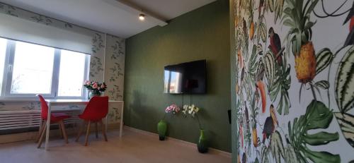 a room with a desk and a wall with a painting at Nameja Apartments in Jēkabpils