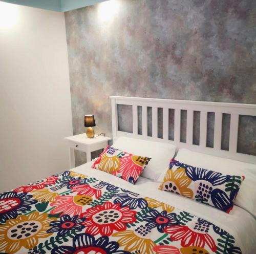 a bedroom with a bed with colorful sheets and pillows at Costantino Home in Pompei