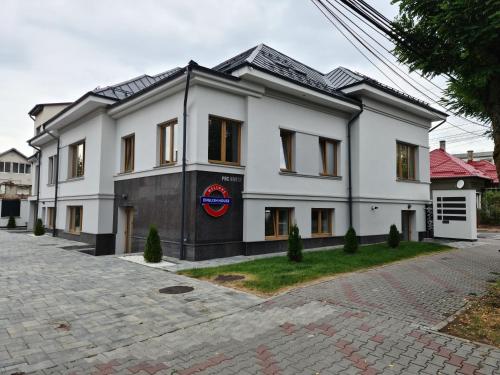 a white building with a red circle on it at English House in Bistriţa