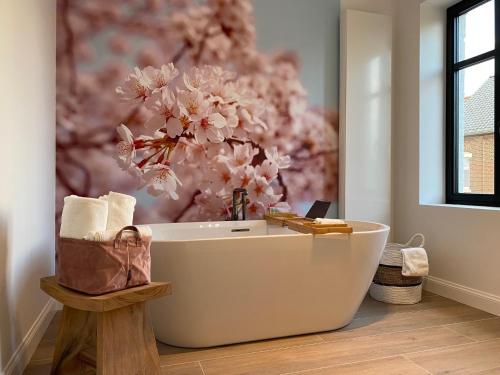 uma casa de banho com uma banheira com uma flor rosa em Luna Logies em Lanaken