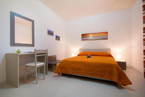 Schlafzimmer mit einem Bett, einem Schreibtisch und einem Stuhl in der Unterkunft Villa del Vento in Birgi Vecchi