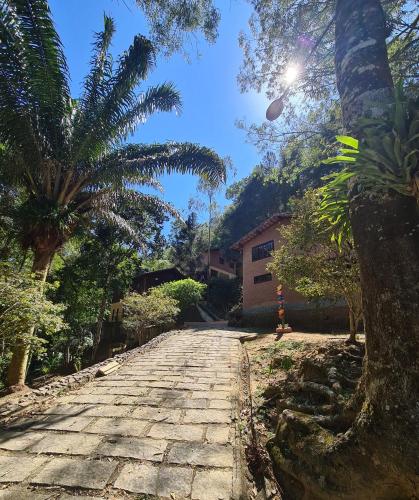 a cobblestone street with palm trees and a building at Recanto dos Sonhos Guest House in Lumiar