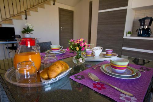 a table with plates of food and a jug of orange juice at Villa del Vento in Birgi Vecchi