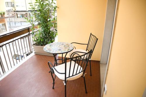 d'un balcon avec une table, des chaises et une fenêtre. dans l'établissement Alloggio Casa Talvena Longarone, à Longarone