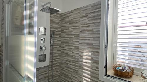 a bathroom with a walk in shower next to a window at Villa DiMari in Santa Maria Del Focallo