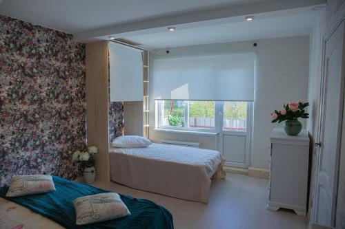 1 dormitorio con 2 camas y ventana en Nameja Apartments en Jēkabpils